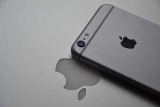 iPhone exposto sobre logo da Apple