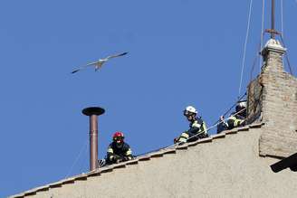 Bombeiros do Vaticano instalam a chaminé no telhado da Capela Sistina para a realização do conclave