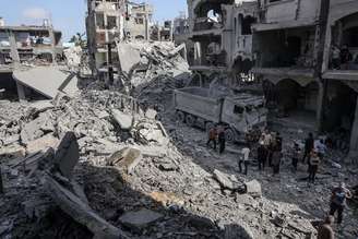 Palestinos realizam trabalhos de busca e resgate entre os escombros após o ataque israelense a uma casa pertencente à família Najjar na região de Jabalia, na Cidade de Gaza, Gaza, em 14 de maio de 2025.