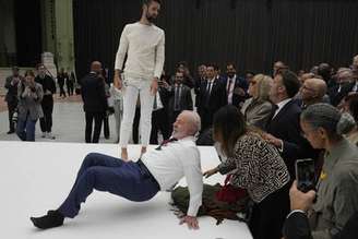 O presidente Luiz Inácio Lula da Silva (PT) tenta reproduzir um movimento de acrobatas durante uma visita à exposição do artista brasileiro Ernesto Neto