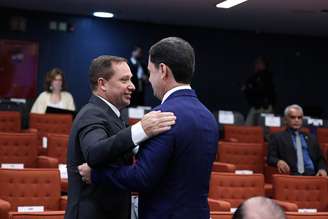 Mauro Cid aperta a mão de Anderson Torres e um leve tapinha no ombro 