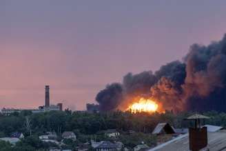 Fogo é visto entre as nuvens de fumaça resultantes de um ataque russo a Kharkiv, Ucrânia, em 7 de junho de 2025. Pelo menos uma pessoa morreu e outras 17 ficaram feridas no ataque, informou o prefeito de Kharkiv, Ihor Terekhov, à RBC-Ucrânia.