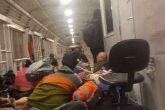 Passageiros abaixados dentro do BRT, no Rio de Janeiro, enquanto tiroteio acontece devido a operação policial