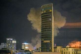 Fumaça sobe após míssil atingir edifício em Tel Aviv, Israel, na madrugada desta segunda-feira, 16