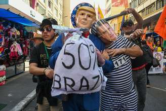 Manifestantes protestam contra falas de Trump na rua 25 de março, em São Paulo