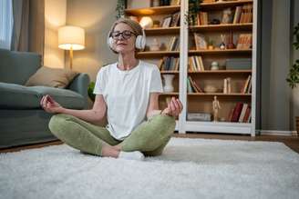 Mulher realizando uma meditação em sua casa