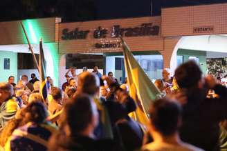 Apoiadores do ex-presidente Jair Messias Bolsonaro (PL) reunidos em uma das entradas do condomínio Solar de Brasília, onde ele mora, em Brasília (DF), na noite desta segunda-feira, 4 de agosto de 2025.