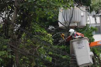 Funcionário da Enel tenta religar a energia após apagão em Moema, na zona sul.