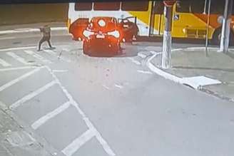 Os criminosos saem do veículo. Um deles dá cobertura aos outros.