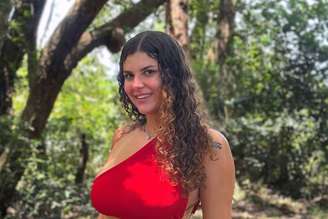 Alê Gaúcha posa para foto em lugar arborizado