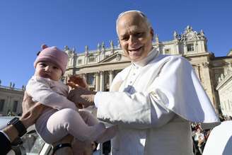 Papa Leão XIV segura criança durante audiência geral na Praça São Pedro, no Vaticano