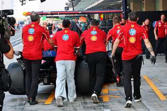 Lewis Hamilton ajuda equipe a empurrar seu carro de volta para garagem