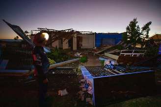 Casas destruídas e um homem olhando para destruição