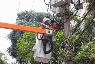 Na foto, funcionário da Enel fazendo conserto em poste de energia elétrica, após relatos de falta de luz.