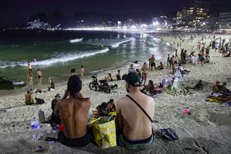 Pessoas aproveitam a praia do Arpoador também à noite, devido ao forte calor