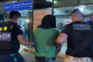 Silvinei Vasques, de capuz, sendo encaminhado à sede da PF