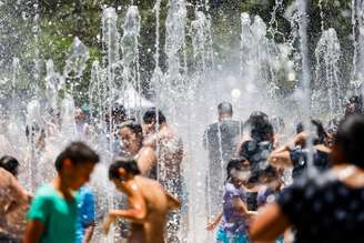 Frequentadores do Parque do Carmo, na zona leste de São Paulo, se refrescam em fonte de água pública.