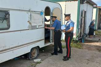 Policiais fazem ronda em assentamento nômade em Castel Romano, na capital italiana, em 2024