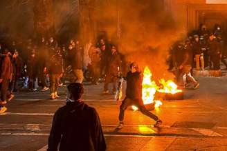 Manifestantes iranianos bloqueiam uma rua em Teerã, em 9 de janeiro. Enquanto a população iraniana está mergulhada em um apagão digital, a mídia estatal e as autoridades começaram a construir sua narrativa preferida dos eventos. MAHSA / Middle East Images / AFP via Getty Images