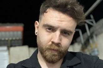 Imagem de comerciante de 26 anos, com cabelo curto e barba