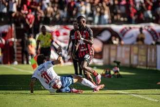 Jogador do Bahia caido no chão dispultando a bola com o jogador do Vitória