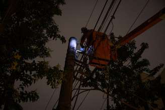 Foto de dezembro de 2025 mostra um funcionário da Enel fazendo reparo na fiação elétrica da Avenida Jandira, após região ficar sem luz