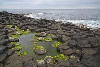 O efeito natural cria a sensação de uma “estrada de pedras” avançando mar adentro, tornando o local um dos cenários geológicos mais famosos do planeta – Wikimedia Commons/ Andrew Mcmillan