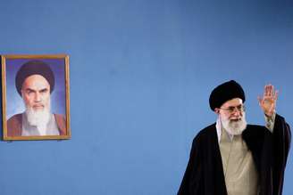 Ali Khamenei diante de foto de Ruhollah Khomeini em Teerã, em abril de 2006