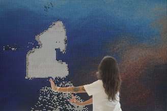 Mulher se diverte com padrões criados na obra Traverse II