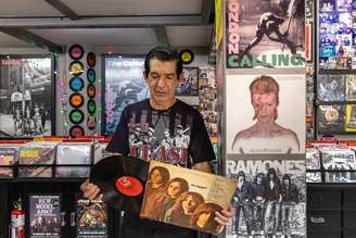 Walter Thiago com o disco de vinil da banda The Stooges em sua loja de LPs London Calling na Galeria do Rock