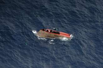 Pessoas se agarram a casco de barco e esperam por resgate no Mar Mediterrâneo