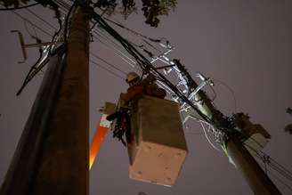 Funcionário da Enel durante trabalho de reparo na fiação elétrica em São Paulo.