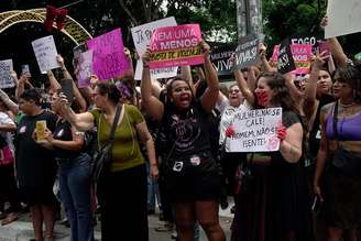 Manifestantes exibem cartazes com mensagens impactantes durante uma marcha para denunciar o aumento dos casos de feminicídio e protestar contra todas as formas de violência contra a mulher, em São Paulo, Brasil