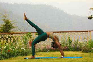 Mulher praticando yoga e representando como usar a prática para soltar o controle