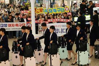 Membros do clube de futebol norte-coreano Naegohyang Women's FC passam por ativistas que os aplaudem enquanto chegam ao Aeroporto Internacional de Incheon para uma partida contra o Suwon FC Women da Coreia do Sul em 20 de maio, em Incheon, Coreia do Sul, em 17 de maio de 2026.  REUTERS/Kim Hong-Ji