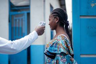 Temperatura de mulher é medida antes de permitir sua entrada em hospital em Goma
