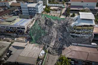 Uma vista aérea mostra os escombros de um prédio que desabou em 24 de maio de 2026 em Angeles, província de Pampanga, Filipinas.