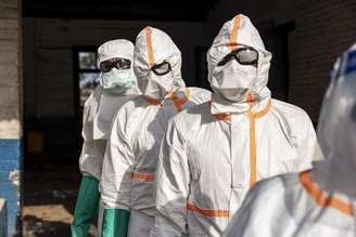 Trabalhadores fazem fila para desinfetar seus equipamentos de proteção no Hospital Geral de Mongbwalu, na República Democrática do Congo, durante o surto de ebola.