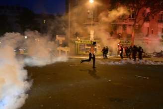 Torcedores do Paris Saint-Germain (PSG) entram em confronto com a polícia durante as comemorações após a vitória do time na Liga dos Campeões da UEFA, em Paris