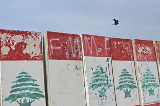 Uma bandeira libanesa colocada sobre blocos de concreto ao longo da costa de Beirute, capital do Líbano, chama a atenção enquanto civis deslocados lutam para sobreviver em abrigos improvisados ​​por toda a cidade, em 14 de abril de 2026. (Foto de Elif Ãztürk/Anadolu via Getty Images)