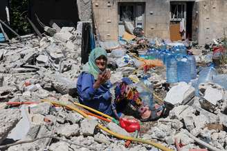 Idosa vasculha escombros em Qlaileh, no sul do Líbano, após bombardeio israelense em 19/6