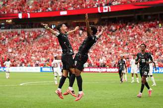 Jonathan David celebra um dos três gols que marcou na goleada sobre o Catar com Stephen Eustaquio –