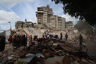 Pessoas e equipes de resgate trabalham nos escombros do edifício Moises, na Avenida Anauco, após um terremoto de magnitude 7,2 atingir a Venezuela e outras regiões do Caribe em 25 de junho de 2026, em Caracas, Venezuela.
