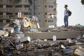 Homem caminha sobre escombros em Catia la Mar, na Venezuela