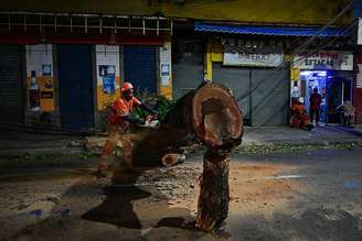 Funcionário corta uma árvore caída após fortes ventos no Rio de Janeiro
