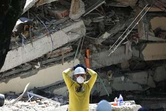 Socorrista diante de prédio destruído por terremoto em Cali, na Colômbia