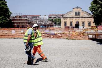 Trabalhadores diante de canteiro de obras em Milão, norte da Itália