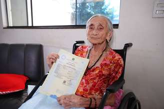 Francisca Antônia de Jesus com sua certidão de nascimento em mãos após 109 anos.