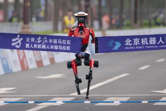 O robô humanoide "Lightning" da Honor, da equipe Qitian Dasheng (Grande Sábio), cruza a linha de chegada durante a Meia Maratona de Robôs Humanoides de Pequim E-Town de 2026, em 19 de abril de 2026, em Pequim, China.