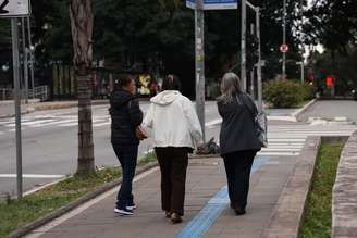 Pessoas usam roupas de frio durante caminhada em via de São Paulo, capital, em foto de 12 de julho de 2026.